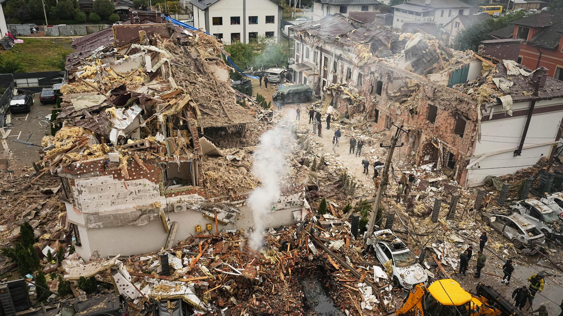 Zerstörte Häuser in der Stadt Kiew im Land Ukraine. Aus den Trümmern steigt Qualm auf. 