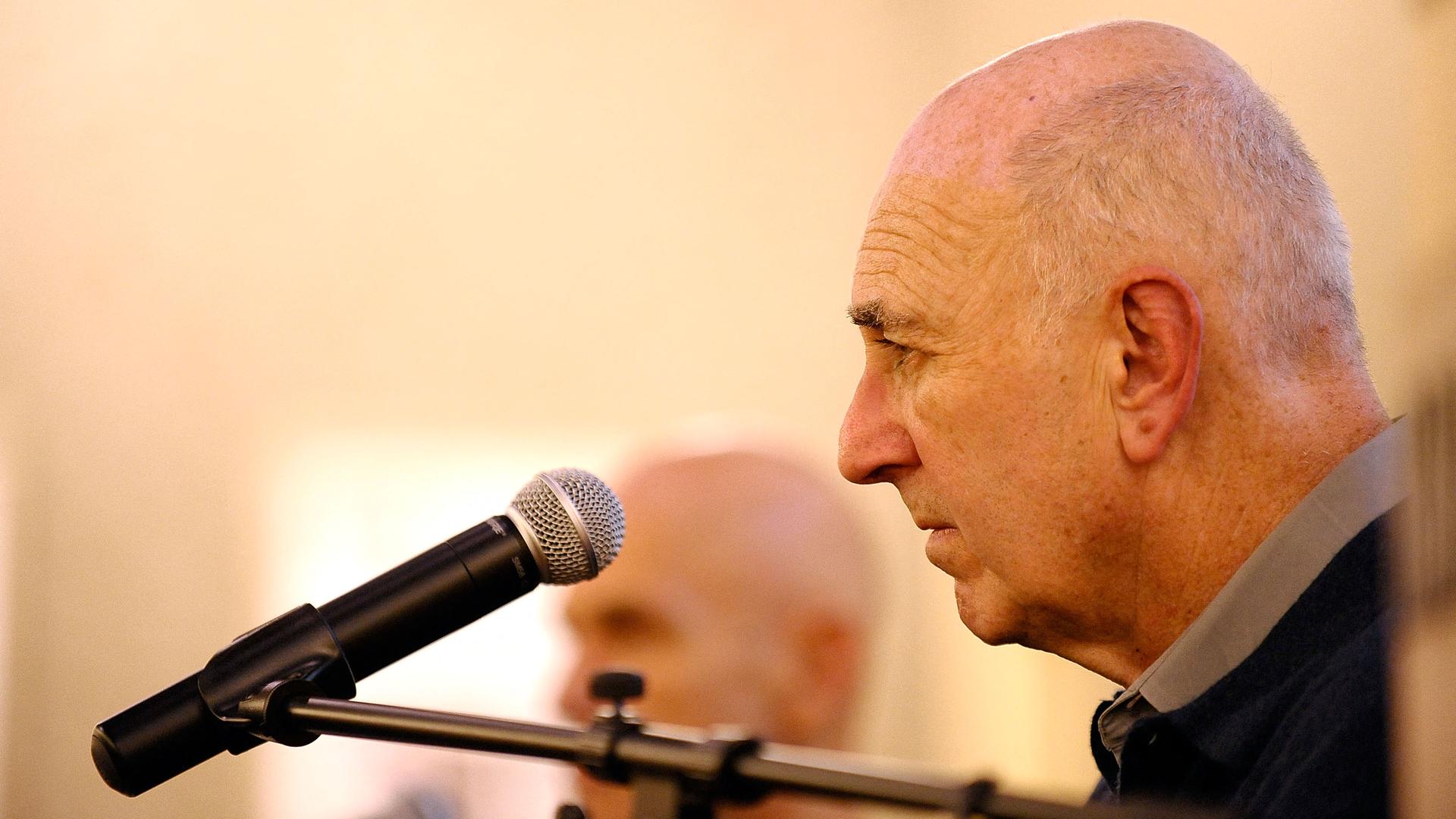 Philipp Lopate im Profil vor einem Mikrofon. Philipp Lopate im Profil vor einem Mikrofon.