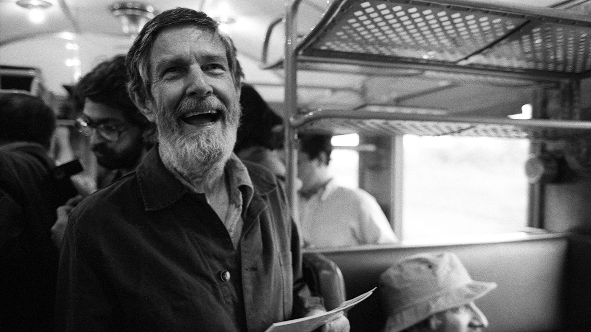 Der Komponist John Cage mit Paier in der Hand im Zug nach Bologna