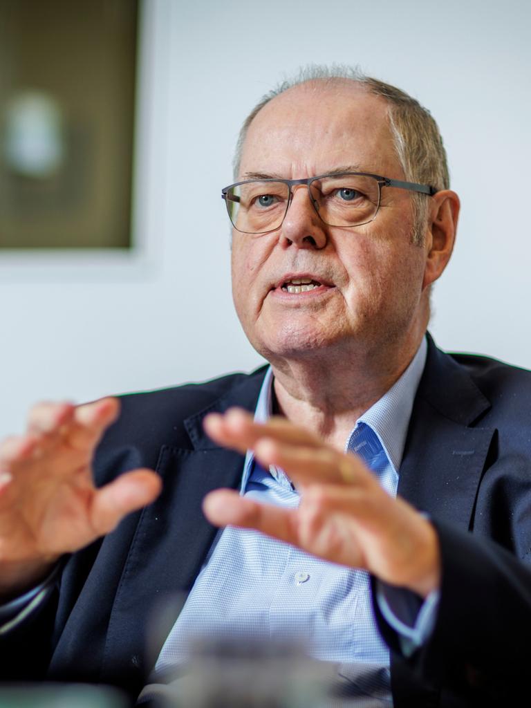 Peer Steinbrück, Bundesminister a.D., SPD, gestikuliert während eines Interviews mit den Händen, im Hintergrund sieht man verschwommen ein Bild an der Wand.