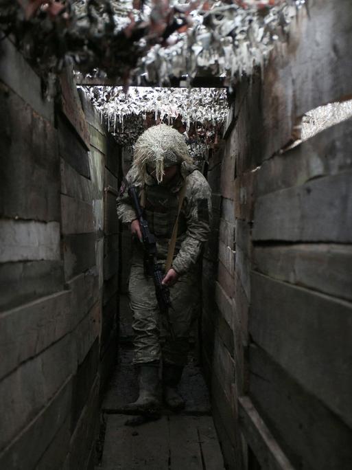 Ein ukrainischer Soldat geht am 10. Dezember 2021 durch einen Graben an der Frontlinie zu von Russland unterstützen Separatisten in Donezk.