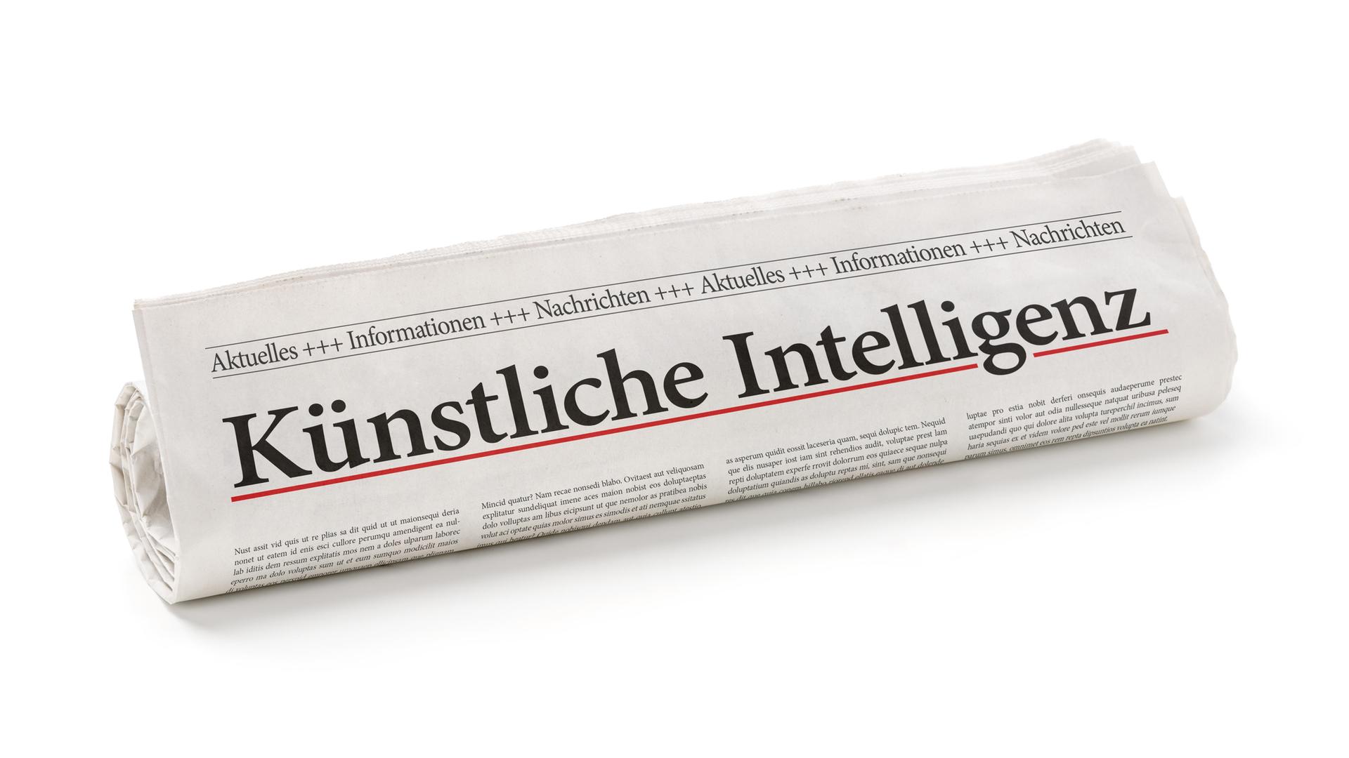 Eine zusammengerollte Zeitung, auf der in großen Buchstaben Künstliche Intelligenz steht.