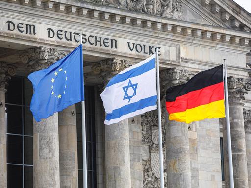 26.01.2022: Die Israelische Fahne zwischen der deutschen und der europäischen Flagge vor dem Reichstag 