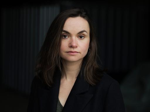 Die Schriftstellerin Franziska Gänsler steht vor einem schwarzen Hintergrund und blickt ernst in die Kamera. Die Schriftstellerin Franziska Gänsler steht vor einem schwarzen Hintergrund und blickt ernst in die Kamera.