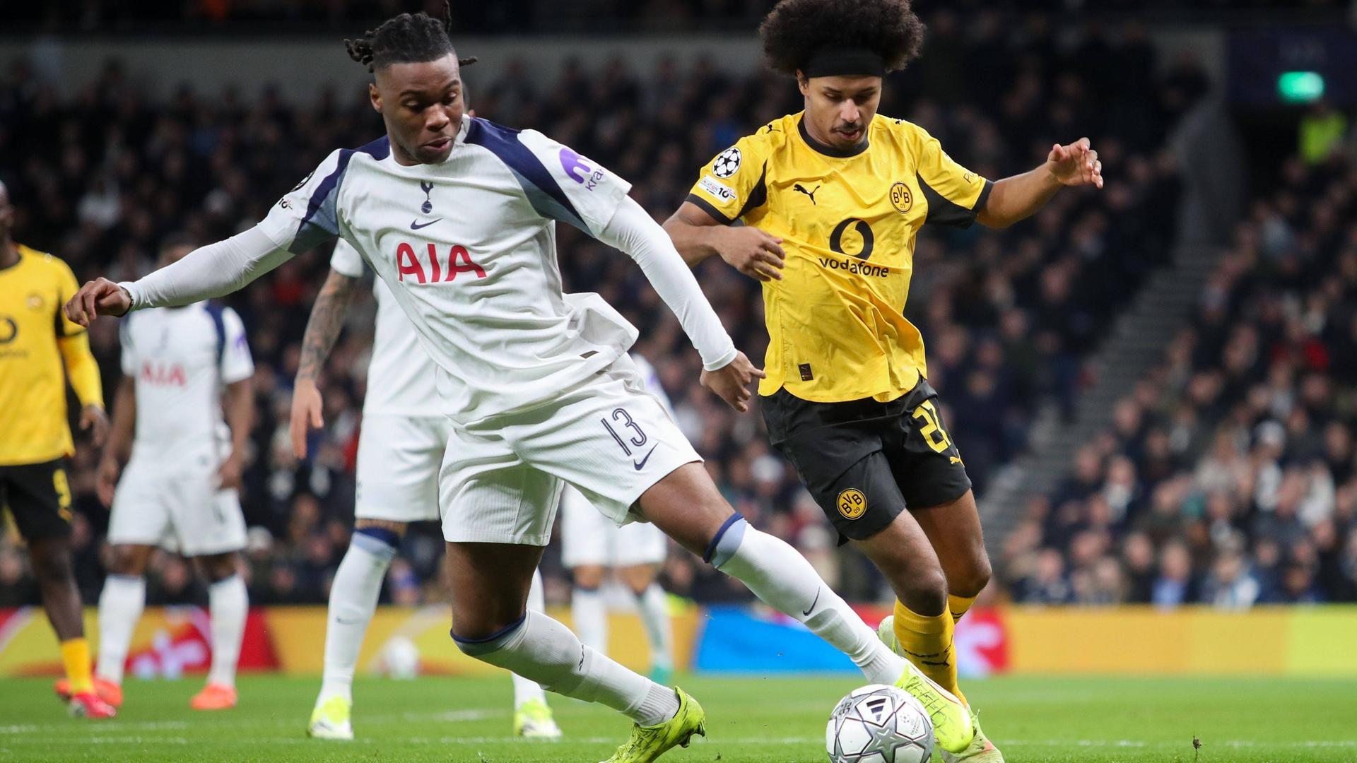 Karim Adeyemi von Borussia Dortmund und Destiny Udogie von Tottenham Hotspur kämpfen um den Ball. 