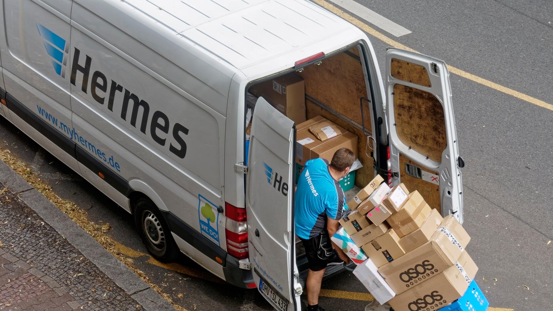 Ein Hermes-Paketboote beim Beladen des Autos Ein Hermes-Paketboote beim Beladen des Autos