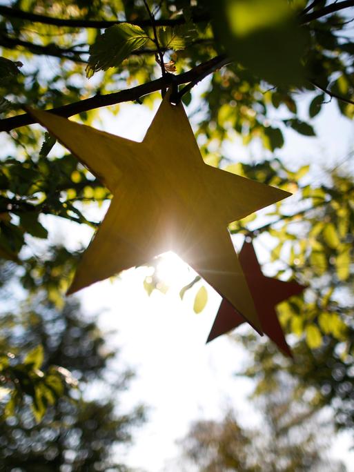 Gebastelte Sterne hängen am in Castrop-Rauxel (Nordrhein-Westfalen) im Rahmen des Projektes "Für jedes verstorbene Kind einen Baum" an einem Baum.