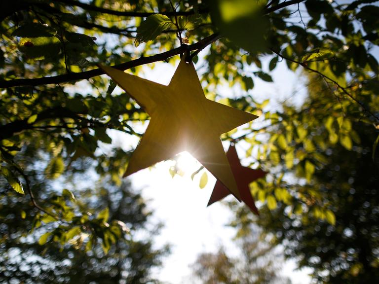 Gebastelte Sterne hängen am in Castrop-Rauxel (Nordrhein-Westfalen) im Rahmen des Projektes "Für jedes verstorbene Kind einen Baum" an einem Baum.