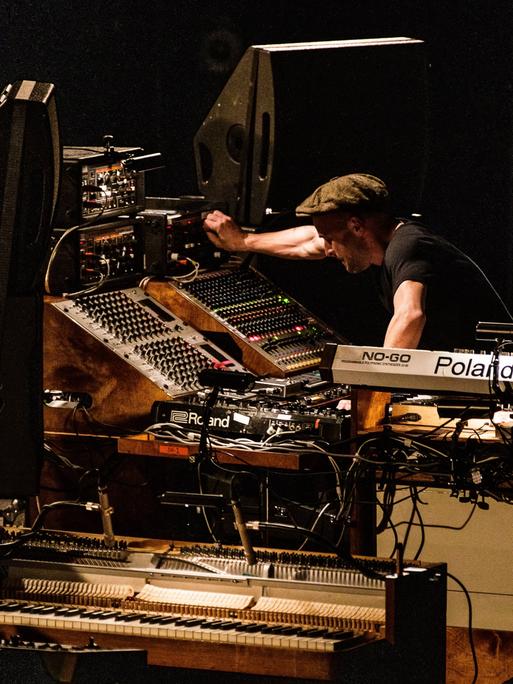 Der Pianist und Komponist Nils Frahm auf der Bühne inmitten seiner Instrumente, Kopenhagen, 2019.