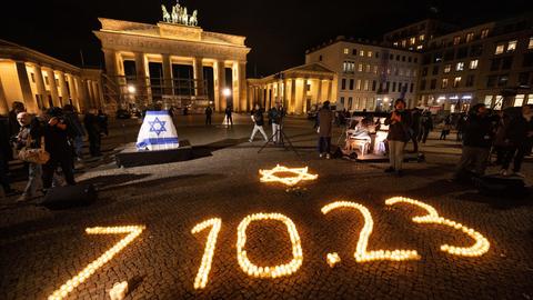 Bei einer Gedenkveranstaltung der Deutsch-Israelischen Gesellschaft für die Opfer des Hamas-Angriffs auf Israel am 7. Oktober leuchten vor dem Brandenburger Tor Kerzen in Form eines David-Sterns und des Datums des Angriffs.