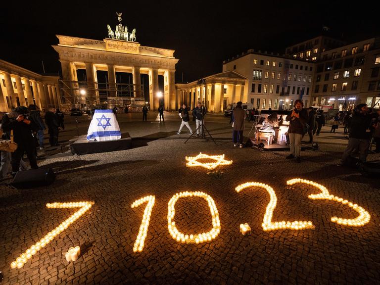 Bei einer Gedenkveranstaltung der Deutsch-Israelischen Gesellschaft für die Opfer des Hamas-Angriffs auf Israel am 7. Oktober leuchten vor dem Brandenburger Tor Kerzen in Form eines David-Sterns und des Datums des Angriffs.