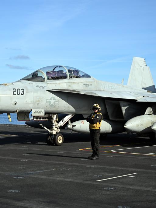 Ein Kampfjet steht auf einem Flugzeugträger bereit. Ein Kampfjet steht auf einem Flugzeugträger bereit.