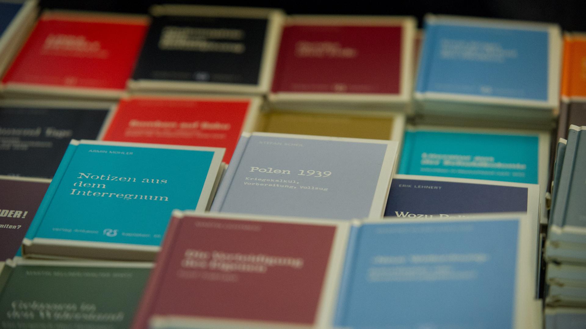 Bücher sind auf einem Tisch ausgelegt. Es sind Bücher aus dem neu rechtem Antaios-Verlag. Die Buchtitel haben eine unterschiedliche Farbe.