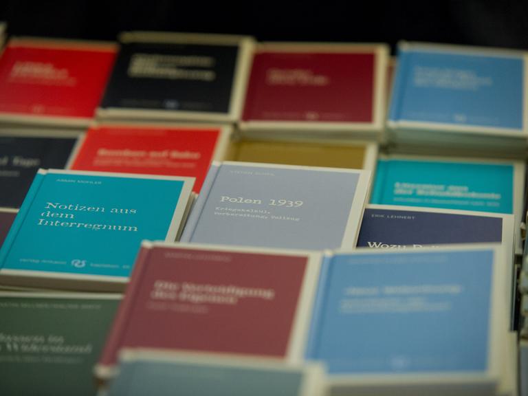 Bücher sind auf einem Tisch ausgelegt. Es sind Bücher aus dem neu rechtem Antaios-Verlag. Die Buchtitel haben eine unterschiedliche Farbe.