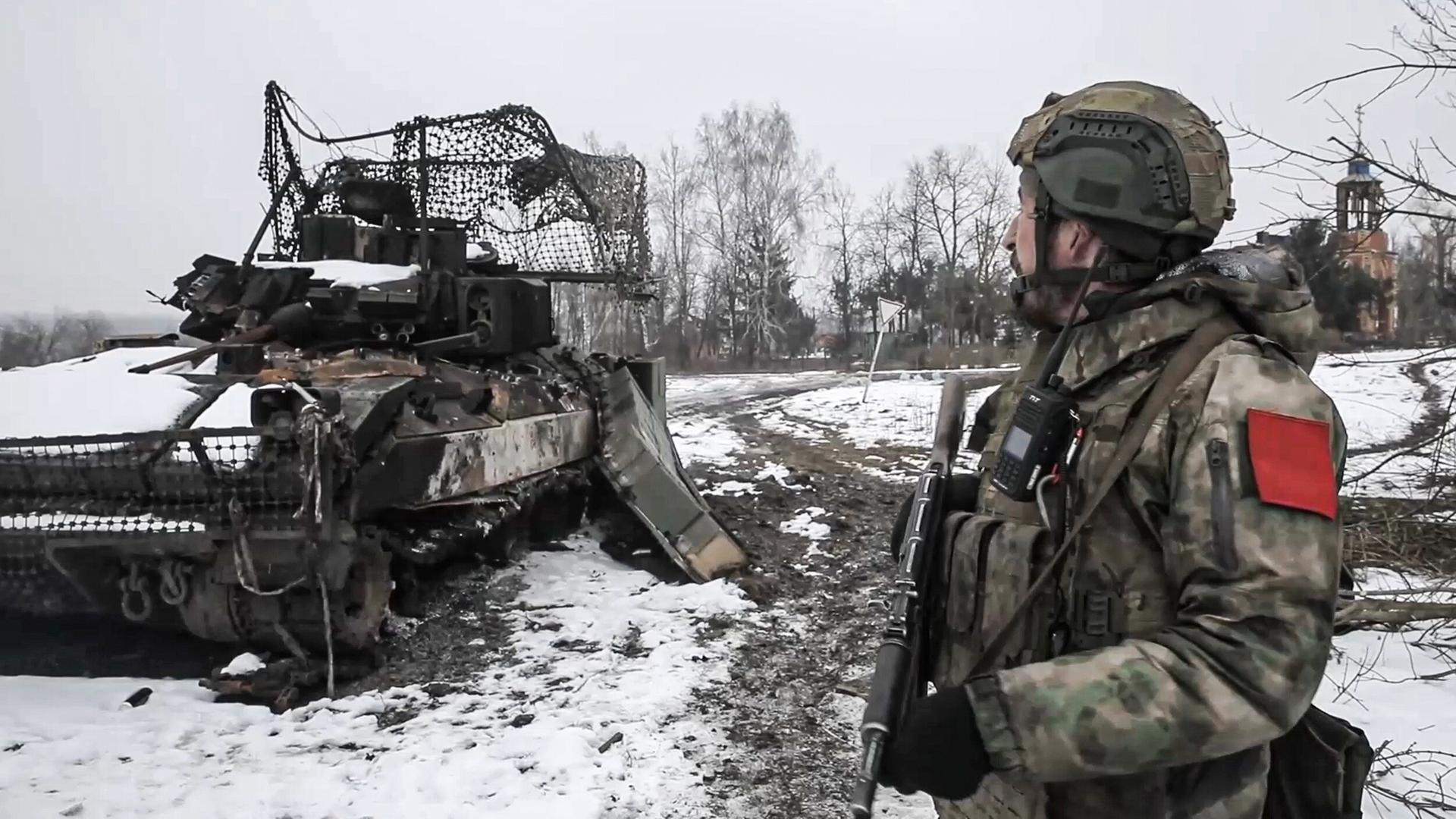 Das Bild zeigt einen russischen Soldaten in einer von der Ukraine zurückeroberten Ortschaft in der Region Kursk. Zu sehen ist auch ein zerstörtes Kettenfahrzeug. 