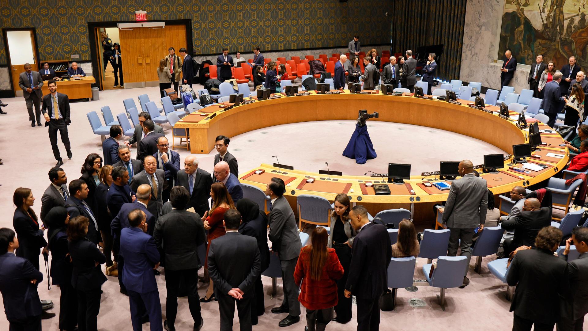 Mitglieder des UN Sicherheitsrats stehen während einer Pause um den runden Beratungstisch herum und unterhalten sich in Grüppchen.