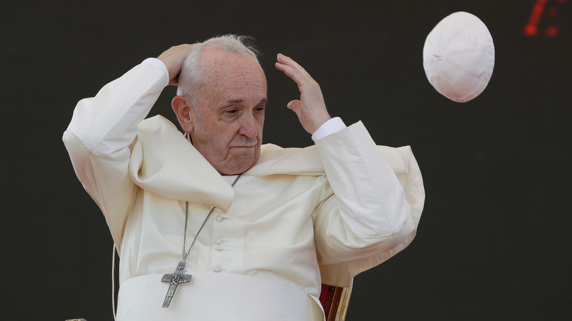 Ein Windstoß weht die Kappe, den Pileolus, von Papst Franziskus weg.