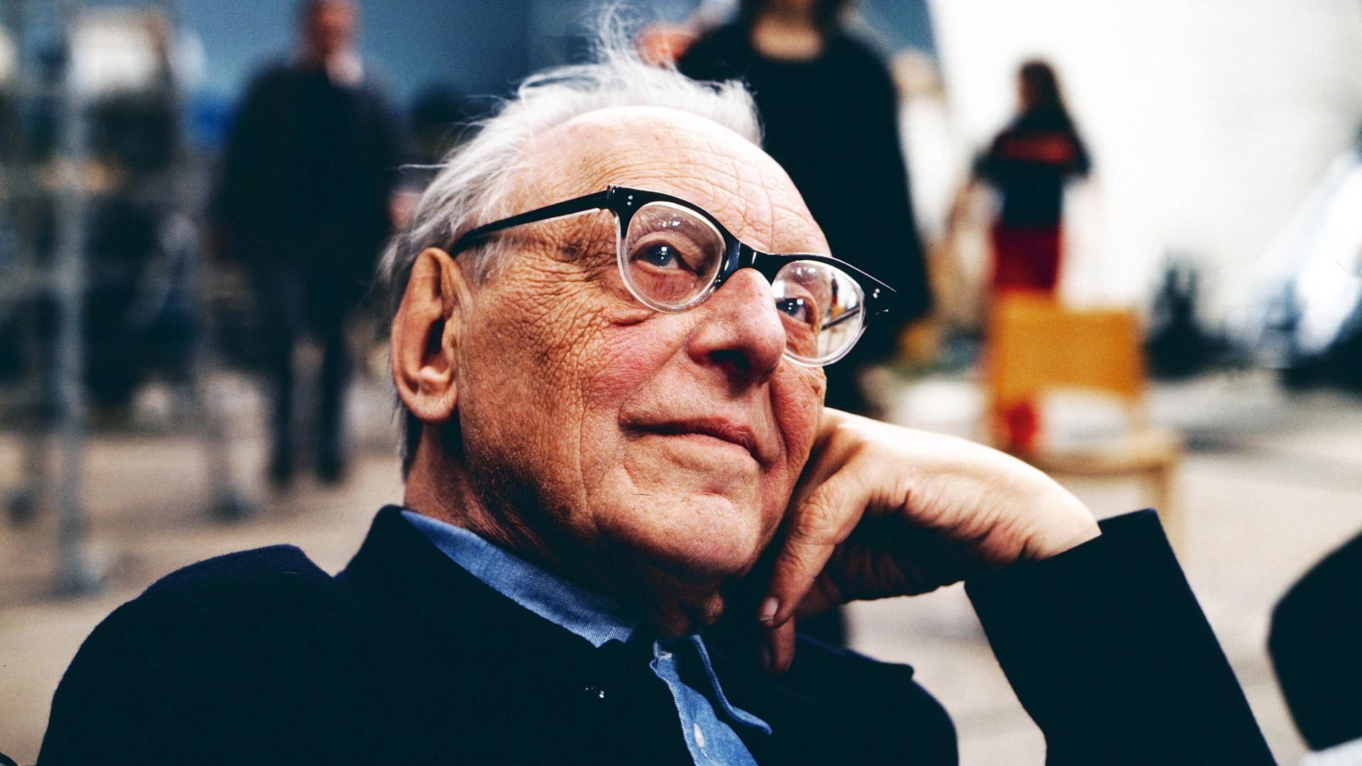 Wir sehen eine Fotografie des Komponisten Carl Orff, auf dem er verträumt in die Kamera schaut.  Wir sehen eine Fotografie des Komponisten Carl Orff, auf dem er verträumt in die Kamera schaut.