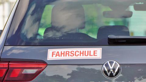 Auf der Heckklappe eines Autos ist ein Aufkleber mit der Aufschrift "Fahrschule" zu sehen.