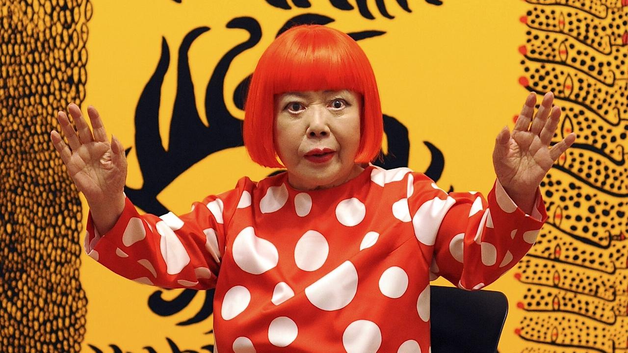 Zu sehen ist die japanische Künstlerin Yayoi Kusama. Sie trägt eine rote Perücke und ein Kleid mit weißen Punkten. Das Foto entstand im Jahr 2012 vor einer Ausstellung in der Stadt London im Land Großbritannien. Zu sehen ist die japanische Künstlerin Yayoi Kusama. Sie trägt eine rote Perücke und ein Kleid mit weißen Punkten. Das Foto entstand im Jahr 2012 vor einer Ausstellung in der Stadt London im Land Großbritannien.