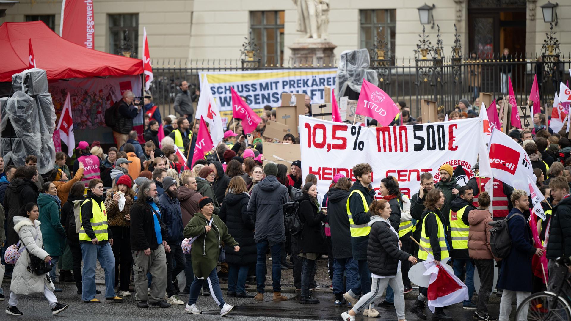 Teilnehmer stehen während eines Warnstreiks an den Berliner Hochschulen vor der Humboldt-Universität zu Berlin.