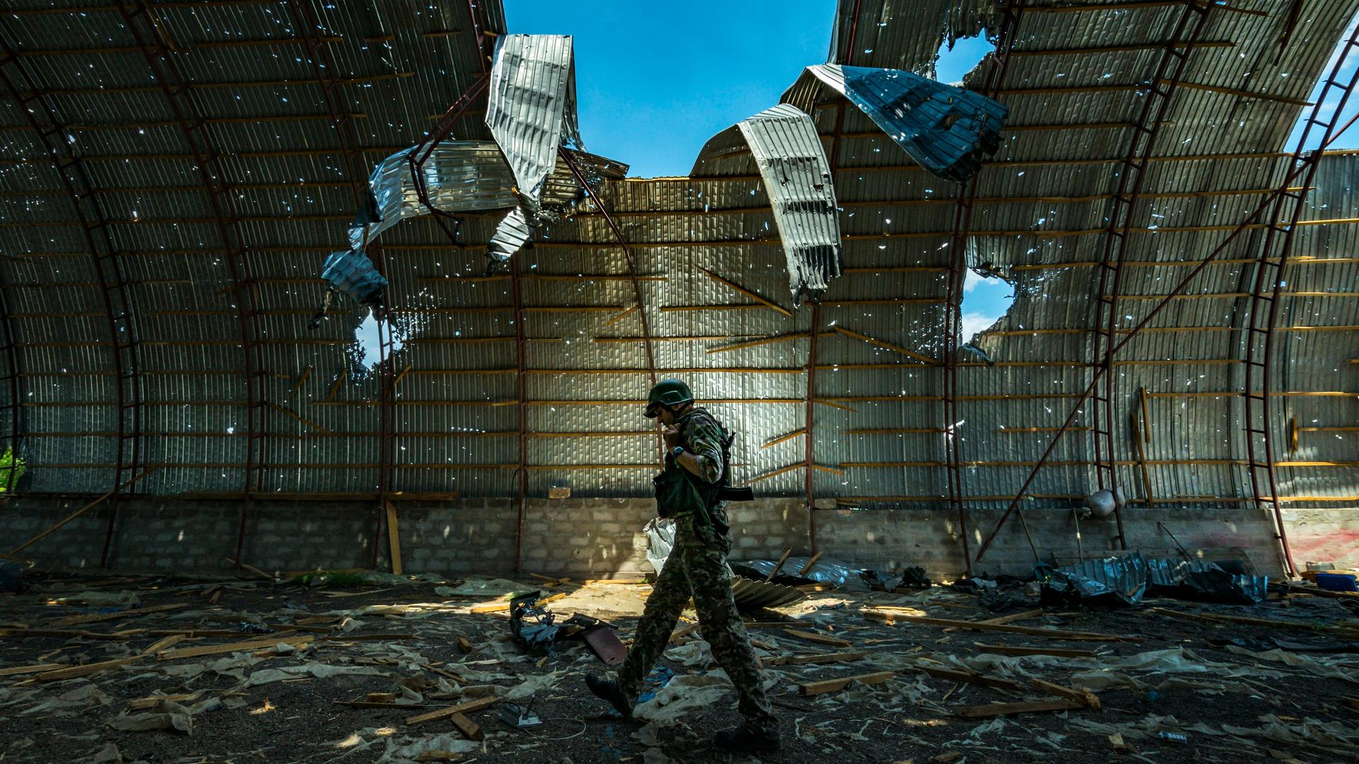 Ein ukrainischer Soldat läuft durch einen halb zerstörten Getreidespeicher.
