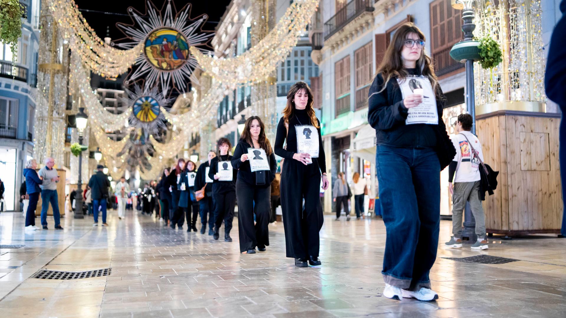 Das Foto zeigt Frauen, die in einer Reihe durch die Stadt gehen. Alle sind schwarz gekleidet. Das Foto zeigt Frauen, die in einer Reihe durch die Stadt gehen. Alle sind schwarz gekleidet.