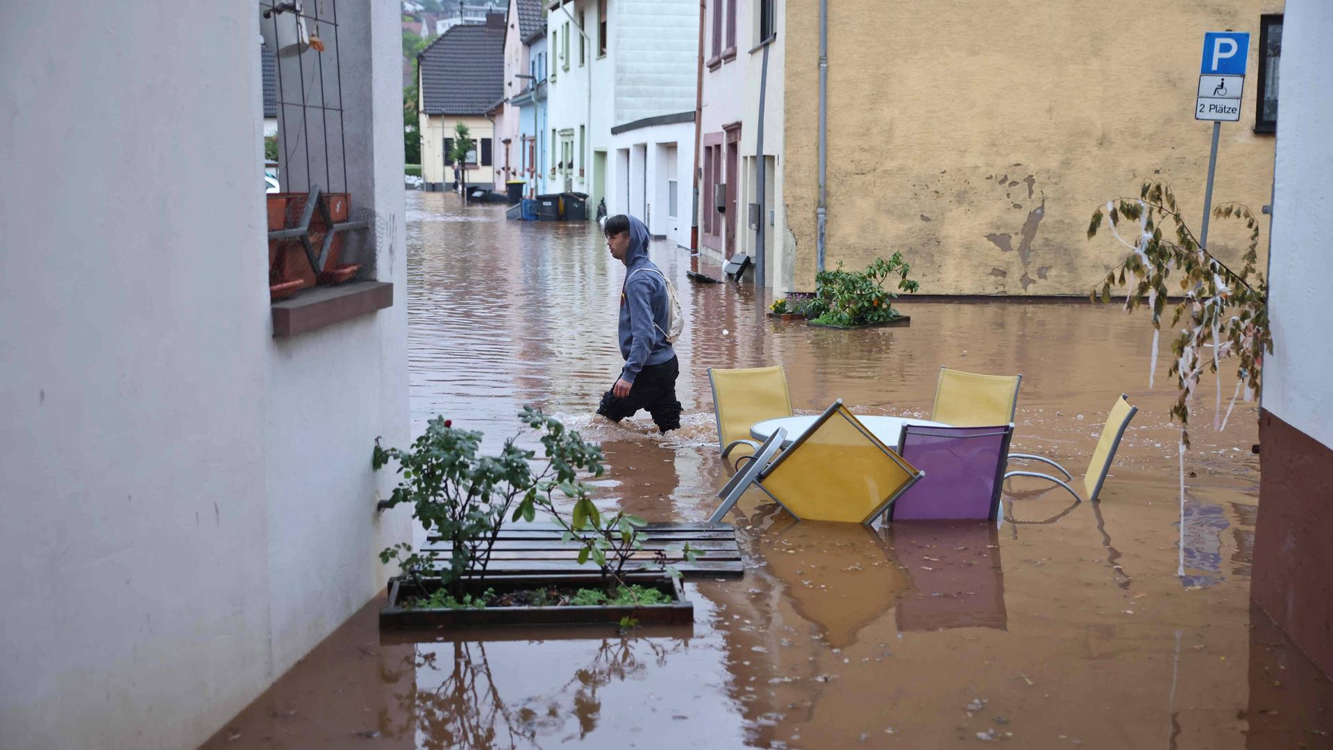 Ein Mann läuft durch das kniehohe Wasser in der Altstadt von Ottweiler.