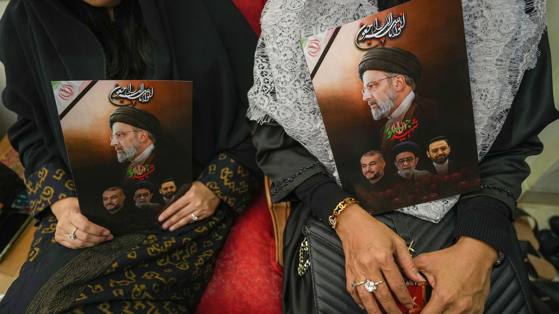 Zwei Frauen halten Fotos des verunglückten iranischen Präsidenten Raisi. Zwei Frauen halten Fotos des verunglückten iranischen Präsidenten Raisi.