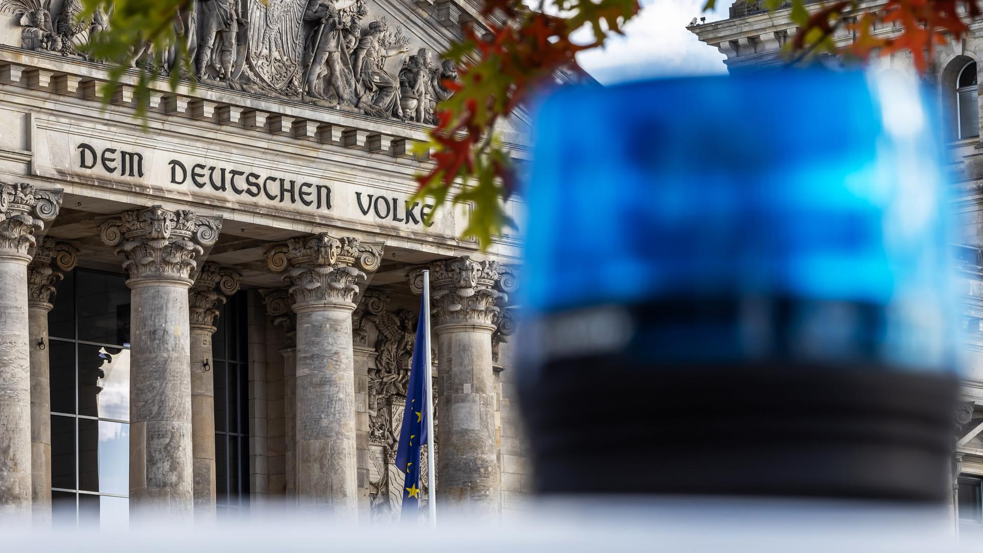 Ein Blaulicht vor dem Bundestag. Im Hintergrund steht "Dem deutschen Volke".