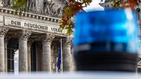 Ein Blaulicht vor dem Bundestag. Im Hintergrund steht "Dem deutschen Volke".