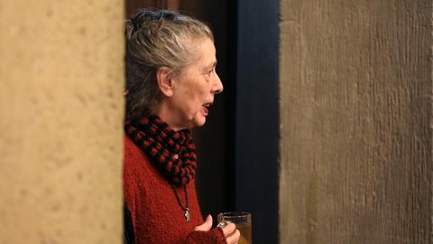 Die Liedermacherin Bettina Wegner lehnt an einem Türrahmen und blickt gedankenverloren nach rechts.