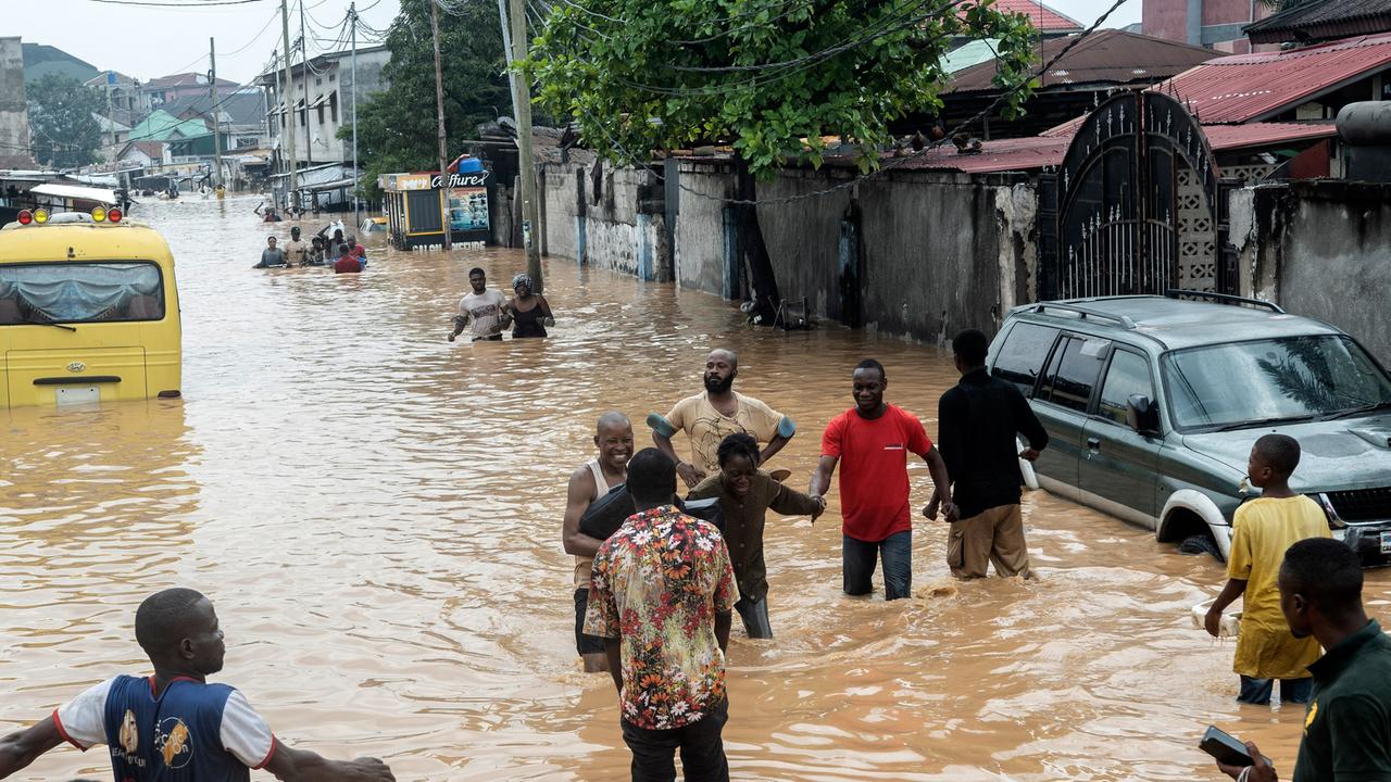 Menschen laufen durch die überfluteteten Straßen von Kinshasa, DR Kongo, am 6. April 2025.