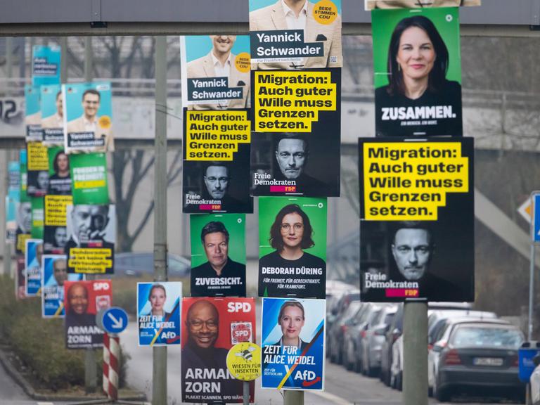 Wahlplakate der etablierten Parteien CDU, AfD, Bündnis 90/Die Grünen, SPD und FDP hängen im Frankfurter Nordwesten an mehreren Laternenmasten. Auf einem Plakat der FDP steht "Migration: Auch guter Wille muss Grenzen haben".