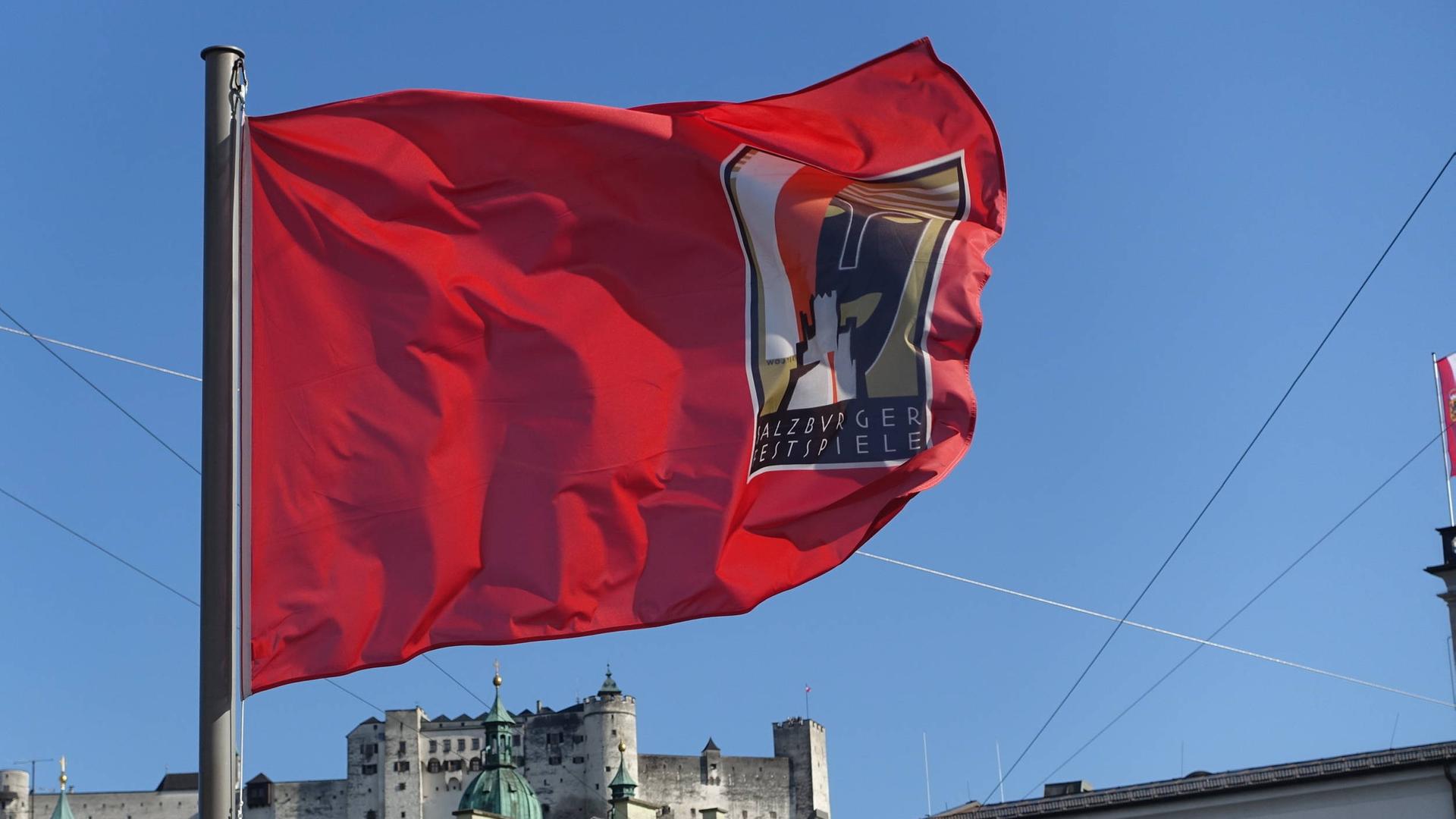 Wir sehen eine rote Fahne. Auf ihr steht geschrieben "Salzburger Festspiele".
