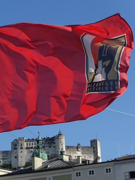 Wir sehen eine rote Fahne. Auf ihr steht geschrieben "Salzburger Festspiele". 