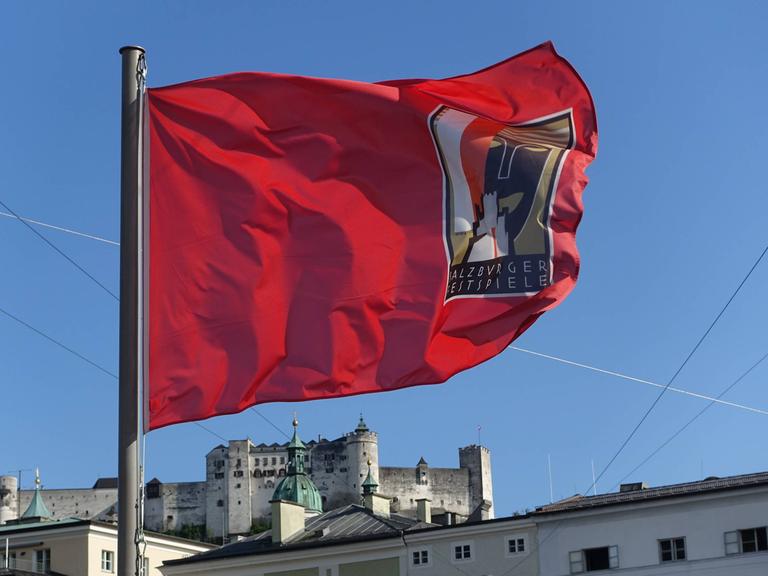 Wir sehen eine rote Fahne. Auf ihr steht geschrieben "Salzburger Festspiele". 