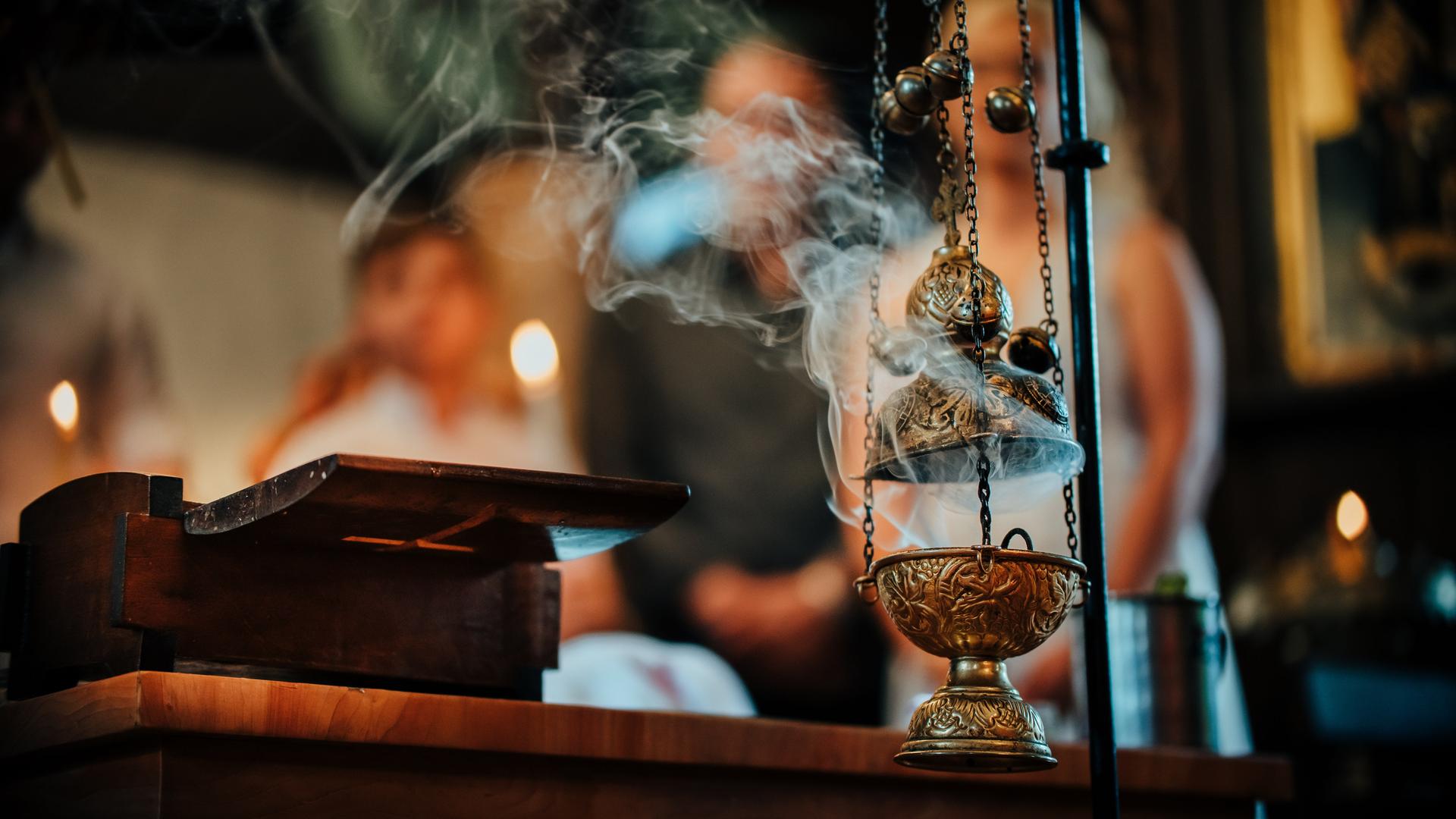 Rauch zieht aus einem Weihrauchgefäß in eine Kirche.