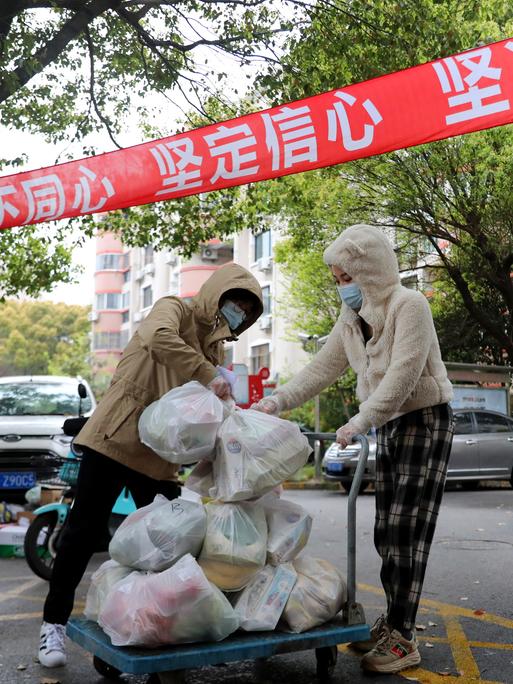 Freiwillige verteilen Lebensmittel in einem Wohnviertel in Schanghai: