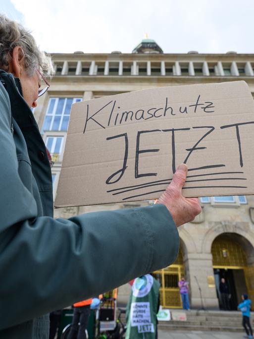 Eine Teilnehmerin eines Bündnisses aus Umweltorganisationen, Wissenschaft und Jugendinitiativen hält bei einer Demonstration in Dresden ein Schild mit der Aufschrift „Klimaschutz jetzt“ in der Hand und fordert u.a. verbindliche Klimaziele.