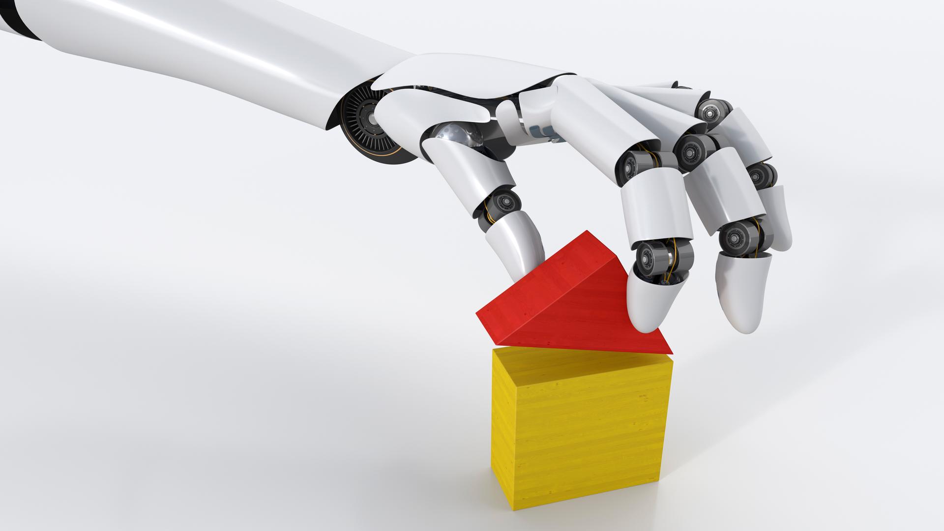 Eine Roboterhand baut mit Holzklötzen ein Haus.