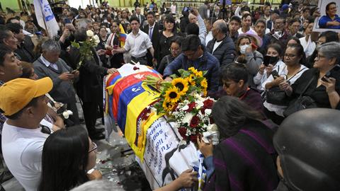 Zahlreiche Menschen stehen am Sarg von Fernando Villavicencio. Auf dem Sarg ist die Flagge Ecuadors drapiert.