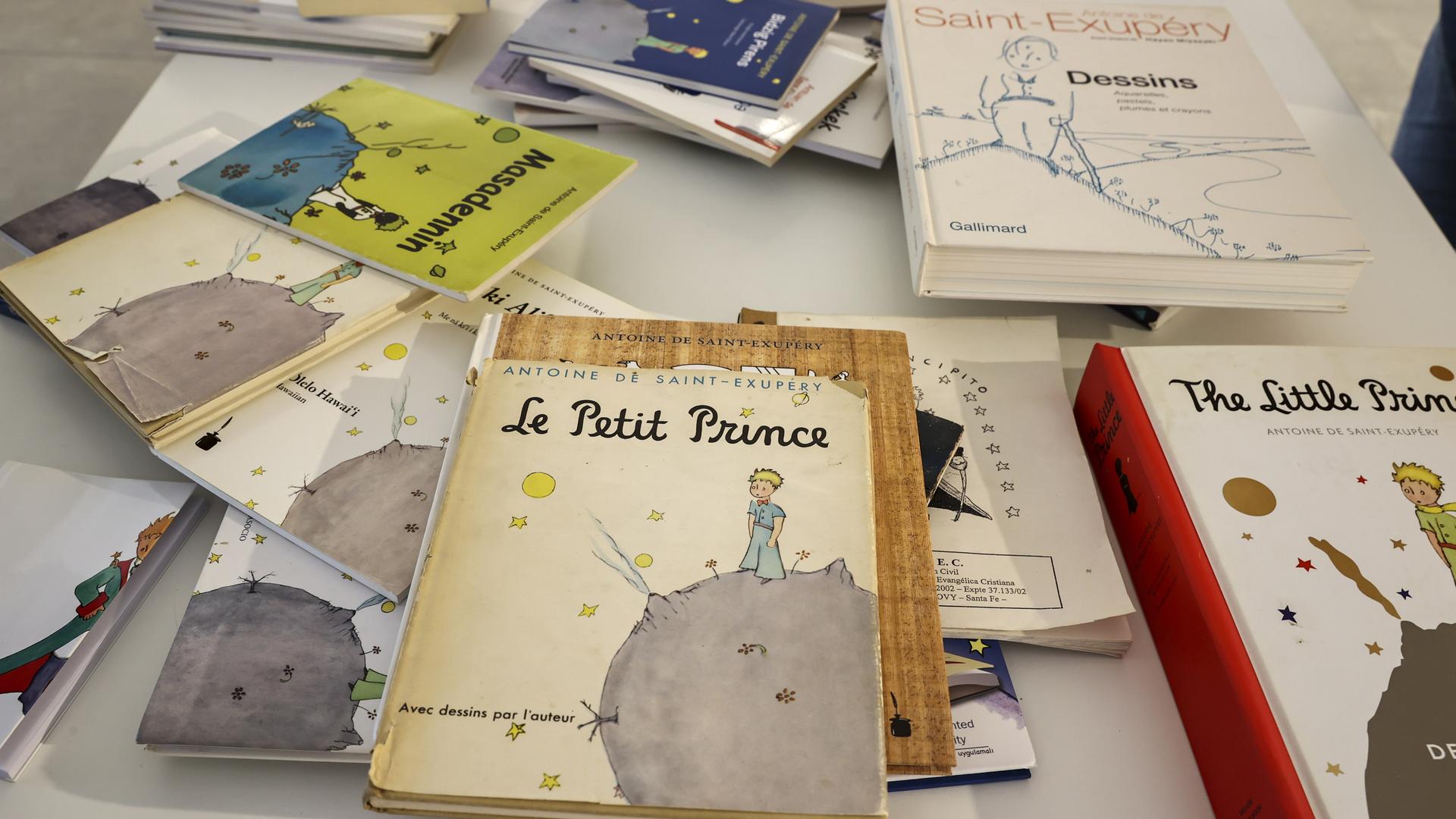 Die Bücher "Le Petit Prince" und "The Little Prince" sowie weitere Ausgaben in anderen Sprachen liegen auf einem Tisch.