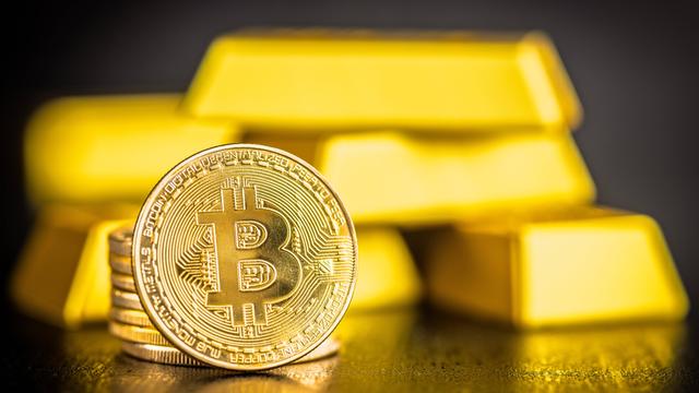 Gold Bitcoin-Münze und Goldbarren auf schwarzem Tisch. 