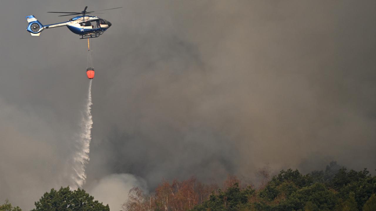 Ein Polizeihubschrauber mit Löschwasser-Außenlastbehälter unterstützt die Löscharbeiten beim Waldbrand im Hürtgenwald. Ein Polizeihubschrauber mit Löschwasser-Außenlastbehälter unterstützt die Löscharbeiten beim Waldbrand im Hürtgenwald.