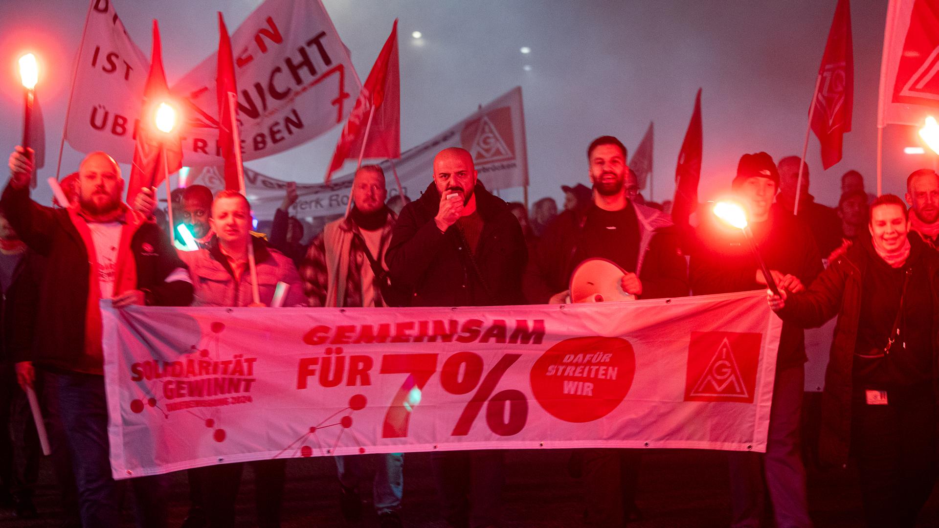 Mitarbeiter der ZF FriedrichshafenÂ AG demonstrieren mit Fahnen und Fackeln vor Tor 2 des Werks. 