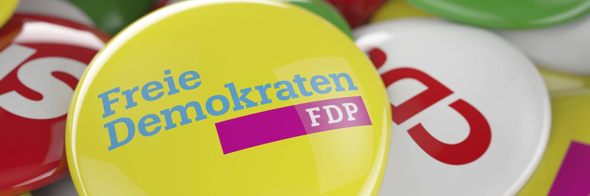 Ein FDP Button liegt auf den Buttons anderer deutscher Parteien.