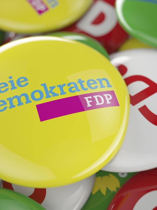 Ein FDP Button liegt auf den Buttons anderer deutscher Parteien.