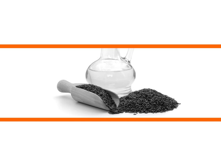 Schwarz-weißes Bild von Leinsamen vor einer Glasflsche mit Öl vor weißem Hintergrund im mittleren Drittel des Bildes. Die beiden weißen Bilddrittel oben und unten sind mit orangenen Streifen abgetrennt.