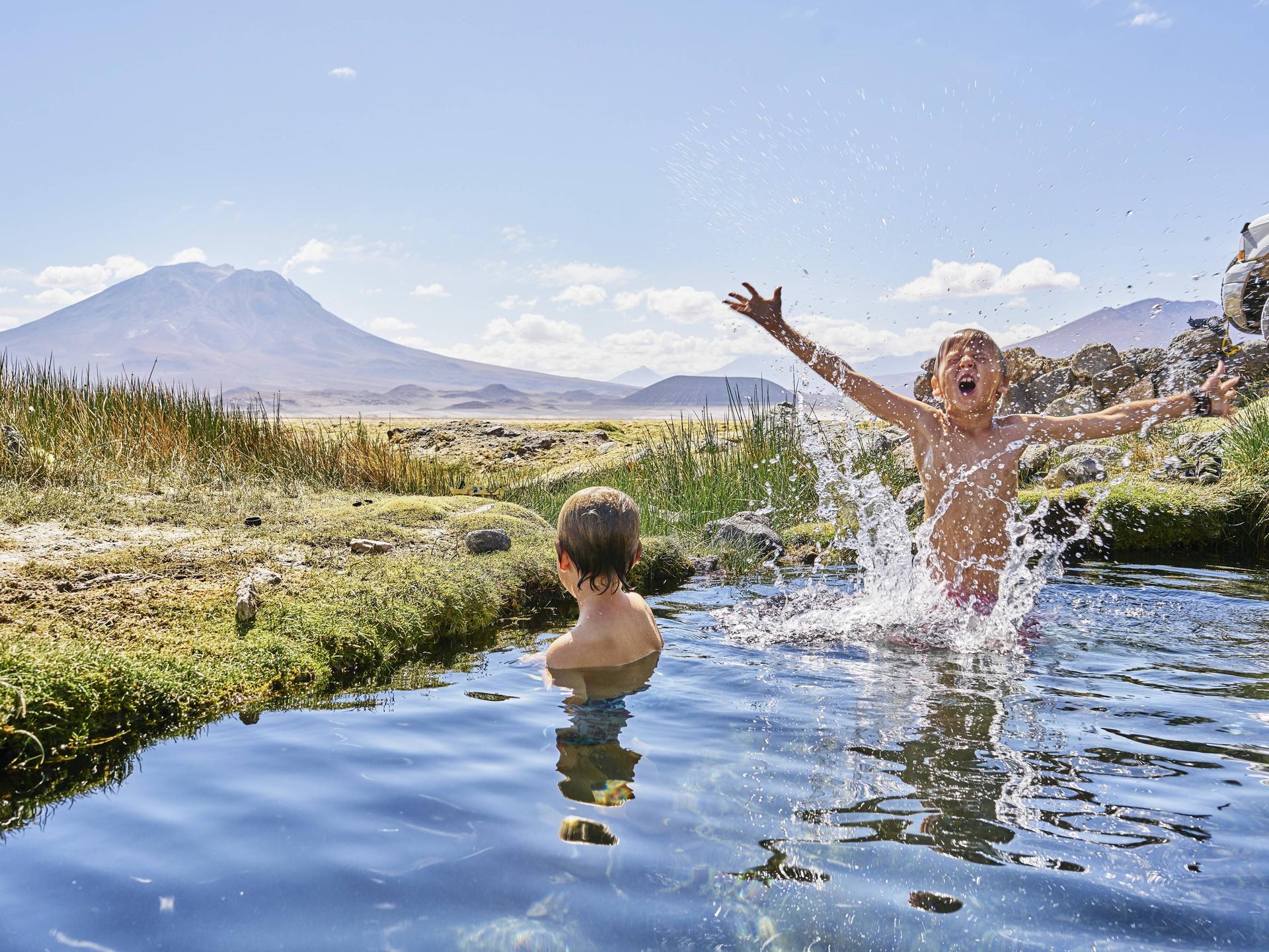Zwei Jungen beim Baden in einer heißen Quelle in Chile.